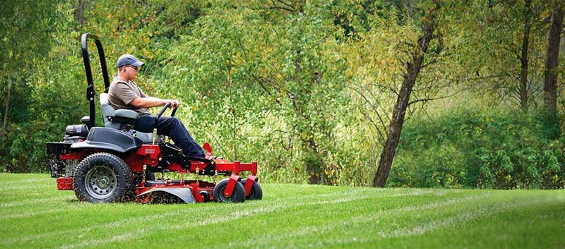 Man mowing a lawn with a commercial mower
